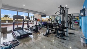 A gym with treadmills, elliptical machines, and weight equipment. - Deck12 2BR Premium Pool Access Parking (Puerto Vallarta)