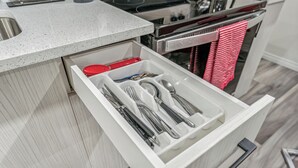 Un cassetto da cucina con utensili e un coperchio rosso.