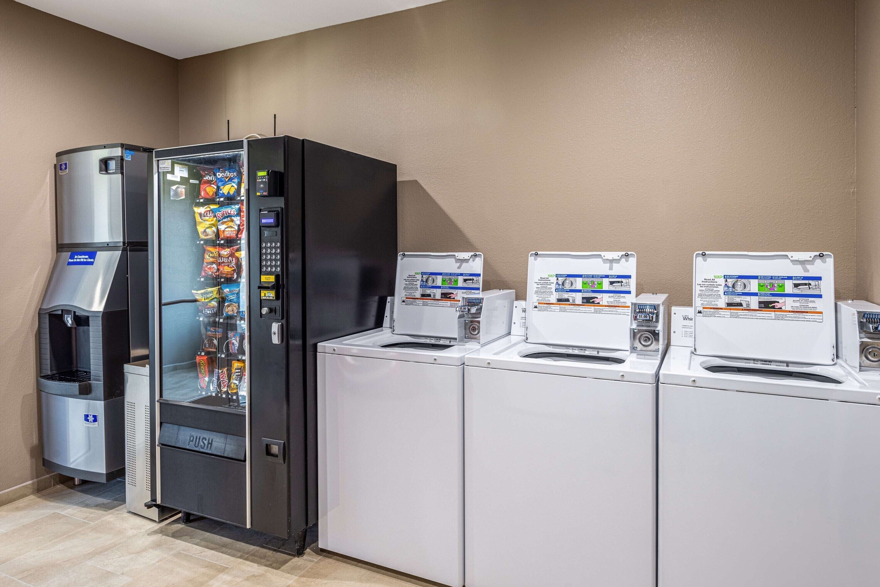 Une chambre d’hôtel équipée d’un mini-bar, d’un distributeur d’eau et d’une machine à laver.