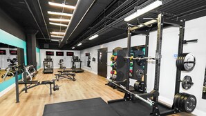 Et fitnesscenter med styrketræningsudstyr, løbebånd og træningsmaskiner.