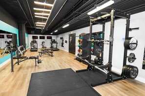 A gym with weightlifting equipment, treadmills, and exercise machines. - Bright 2BR Retreat near McCormick & Museum Campus (Chicago)