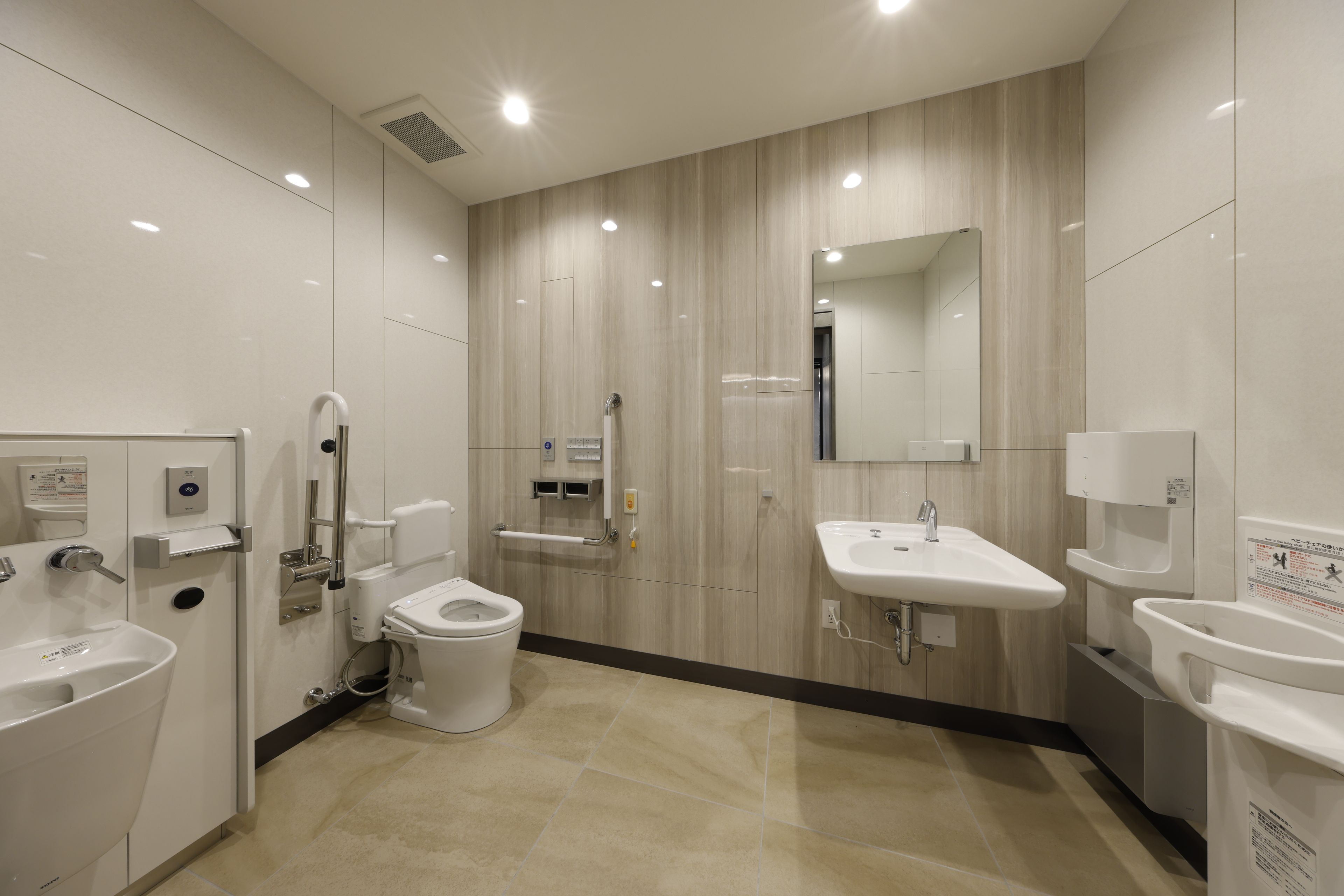 Un baño moderno con inodoro, bidé y dos lavabos.