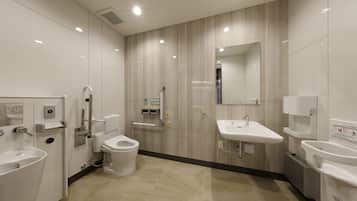 Un baño moderno con inodoro, bidé y dos lavabos.