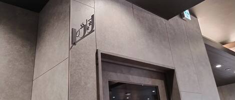 L’entrée d’un hôtel, avec un distributeur automatique et un panneau indiquant l’emplacement de la laverie.