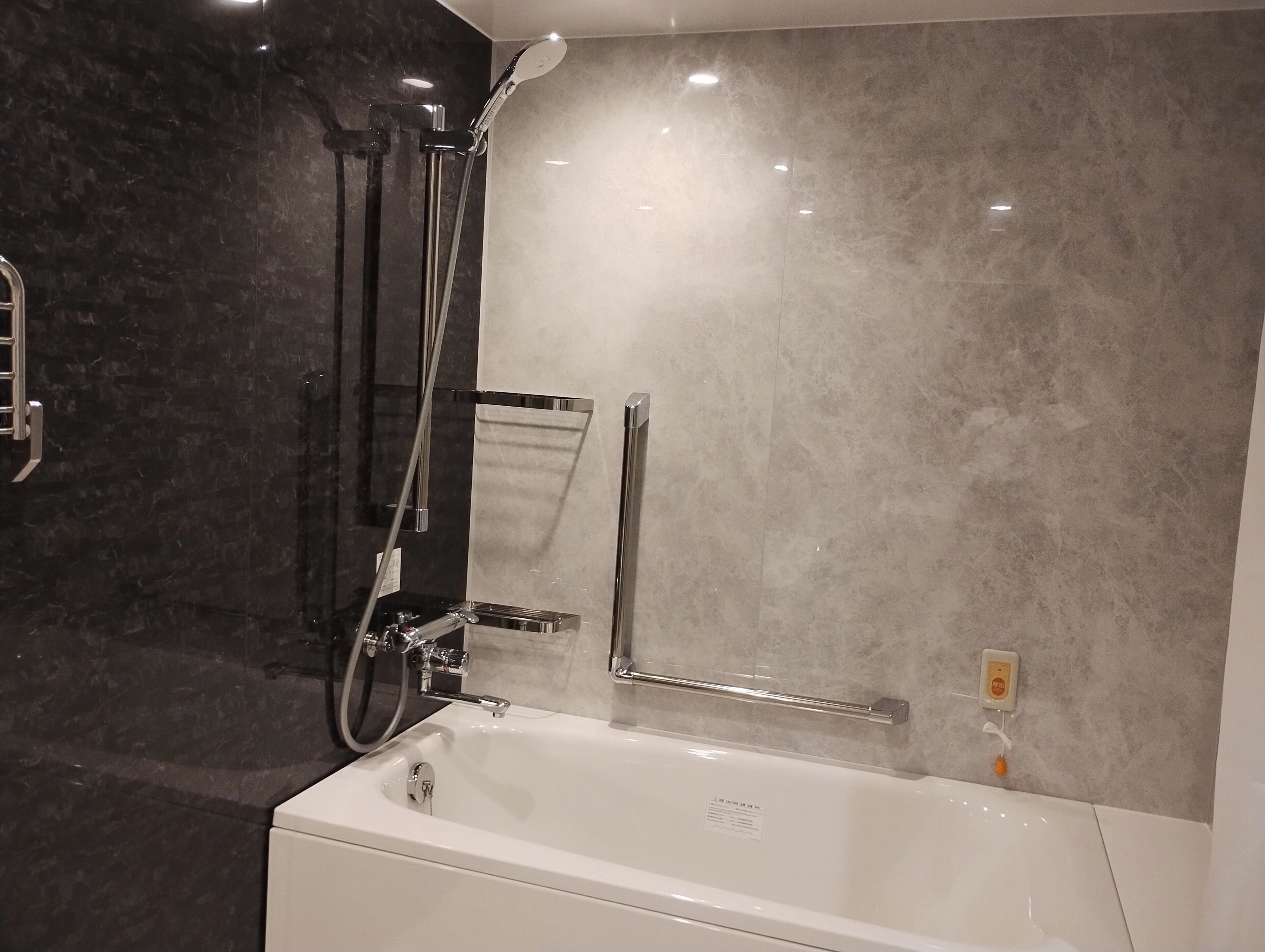Un baño moderno con bañera, ducha y barra de apoyo.