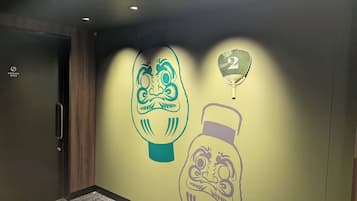 A wall with a large, stylized face and a number '2' in a hanging lantern.
