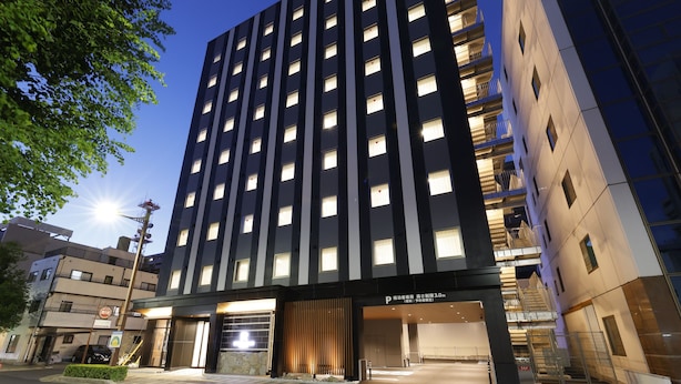 A modern hotel with a central entrance, multiple floors, and a parking area. - HOTEL RAH TAKAMATSU (Takamatsu)