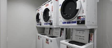 A laundry room with three stacked front-loading washing machines.