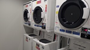 A row of stacked washing machines in a commercial setting. - HOTEL RAH TAKAMATSU (Takamatsu)