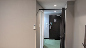 A hallway with a door leading to a room, a thermostat, and a light switch. - HOTEL RAH TAKAMATSU (Takamatsu)