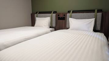 Twin beds with headboards, a control panel, and a green wall.