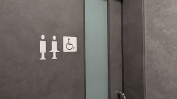 Baño con un letrero que indica baños de hombres y de mujeres, y el símbolo de acceso para discapacitados.