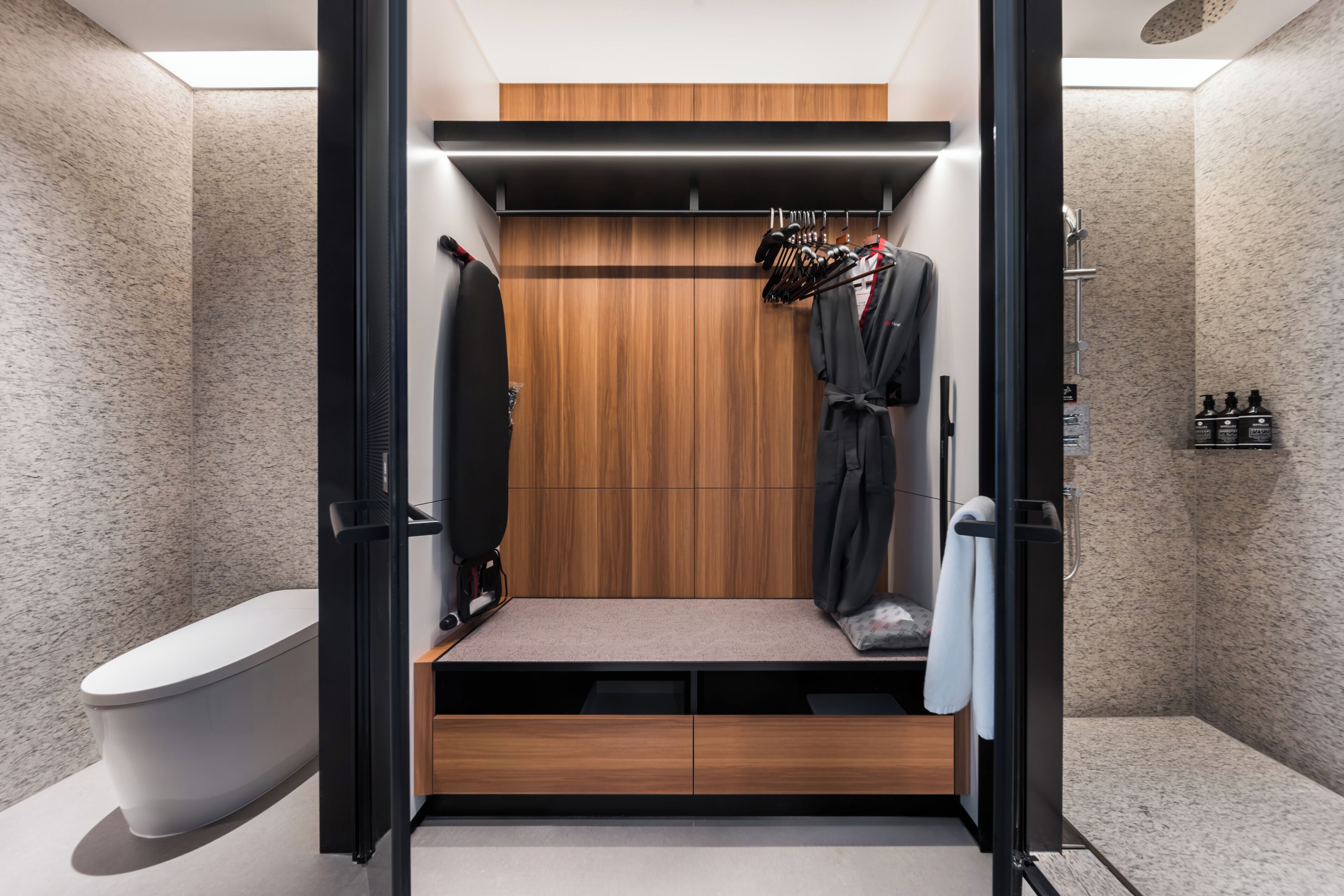 A modern bathroom with a wooden vanity, a toilet, and a shower area.
