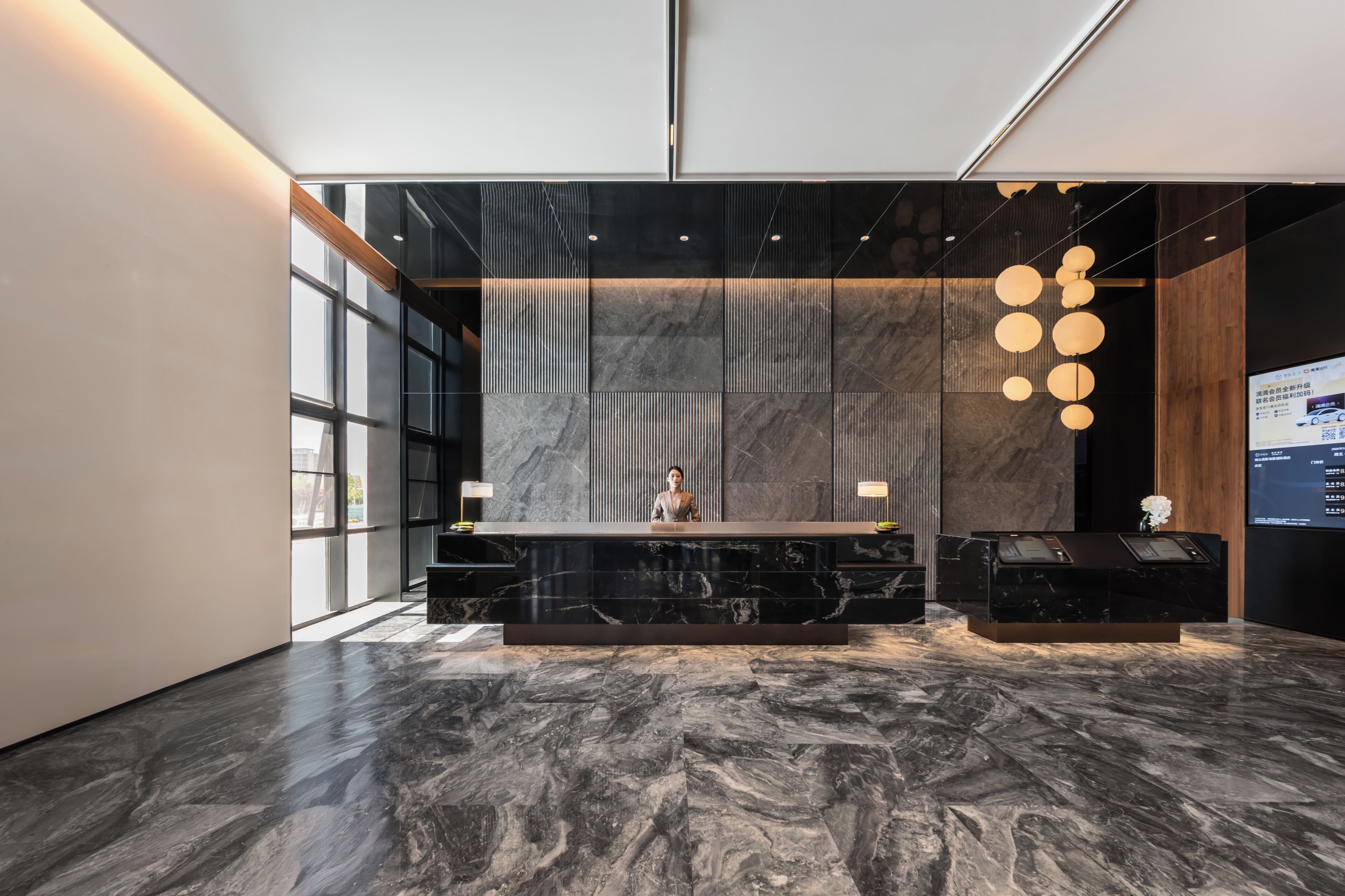 A reception area with a marble floor, a reception desk, and a large window.