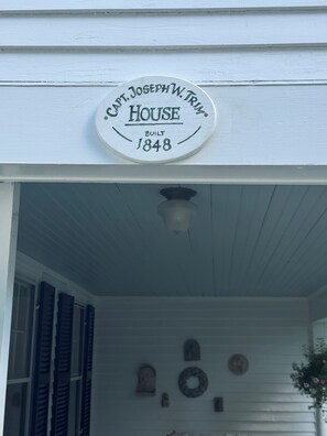 A white house with a sign stating 'Capt. Joseph W. Tripp House Built 1848' above the entrance.