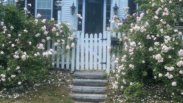 A two-story house with a white picket fence, a front door, and a number '19' above the door. - Step Back in Time, Relax in Modern Comfort (Camden)