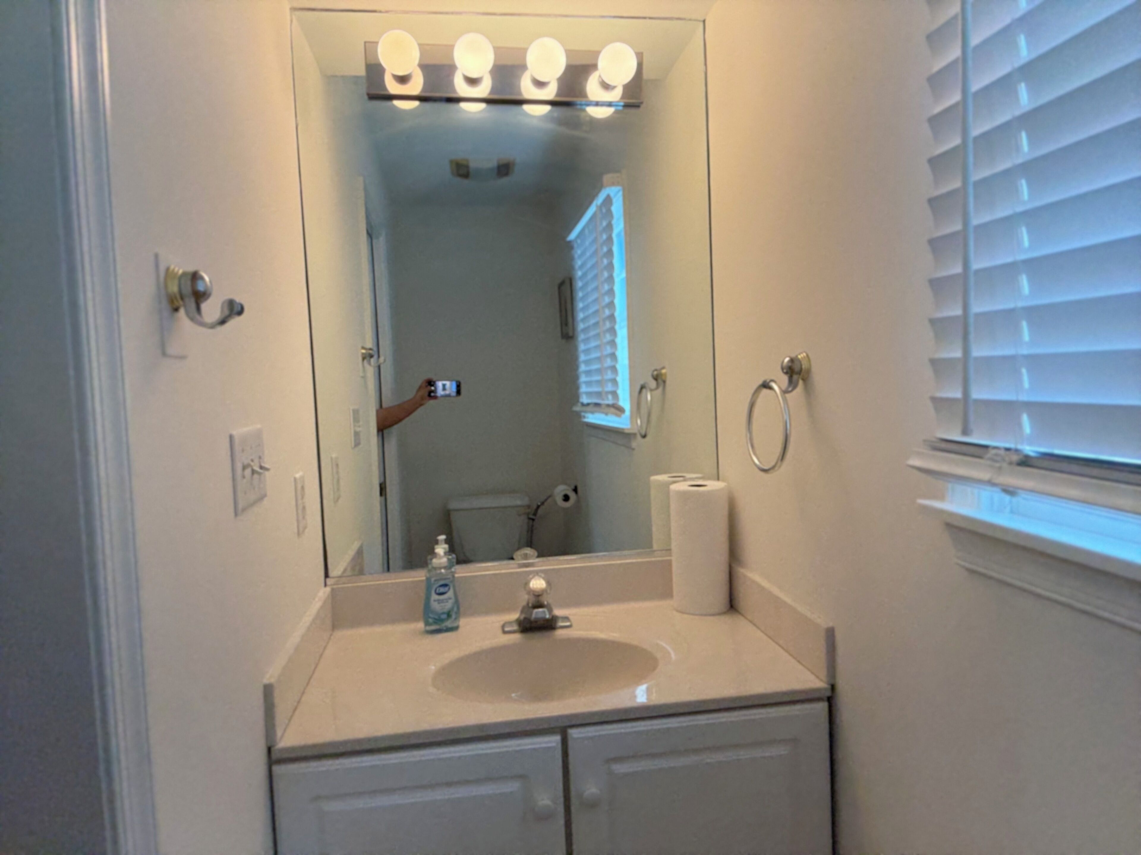 A bathroom with a sink, mirror, and toilet.