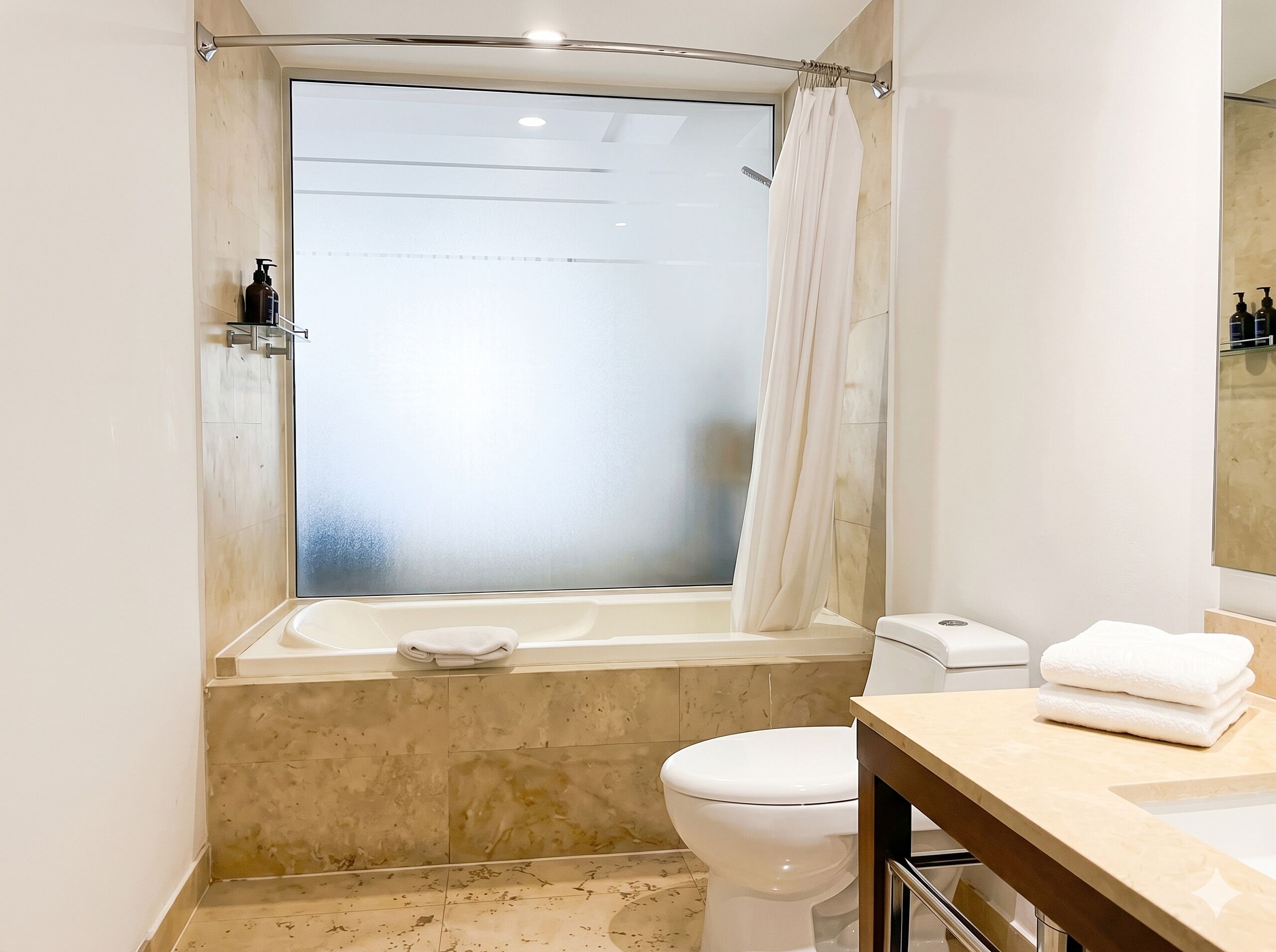 Ein Badezimmer mit Badewanne, Toilette und einem Fenster mit Milchglasblick.