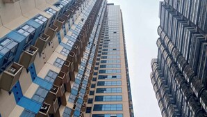 Un immeuble de grande hauteur doté d’une architecture moderne, caractérisé par une série de balcons et de grandes fenêtres.