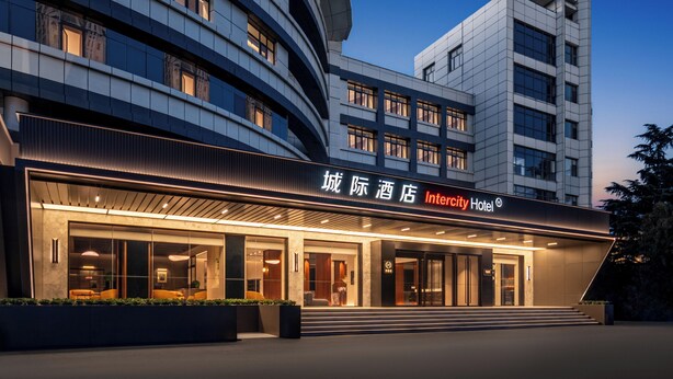 Un hotel moderno con fachada curva, ventanas amplias y una entrada destacada.