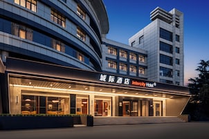 Un hotel moderno con fachada curva, ventanas amplias y una entrada destacada.