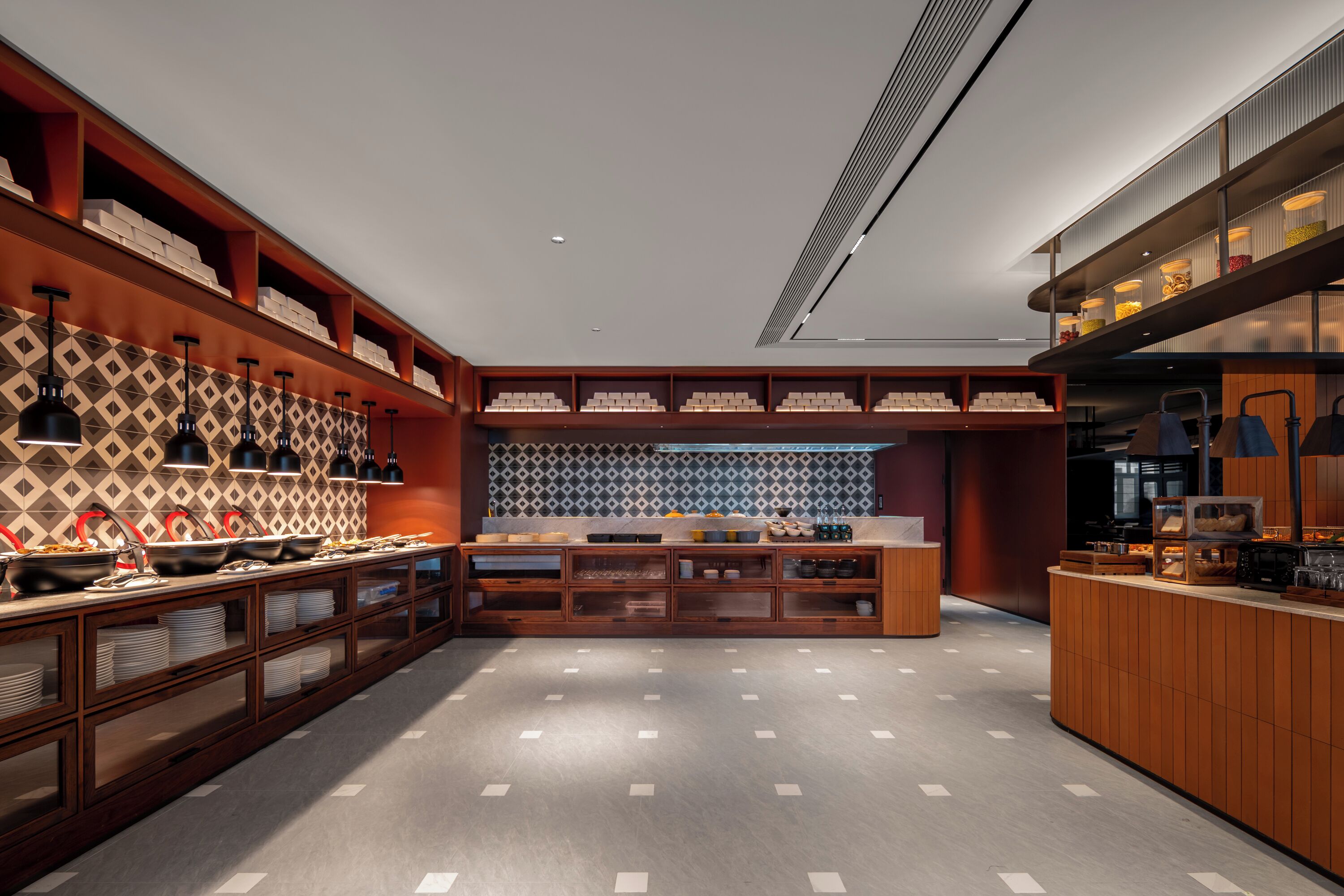 A modern kitchen with built-in shelves, a central island, and a patterned backsplash.
