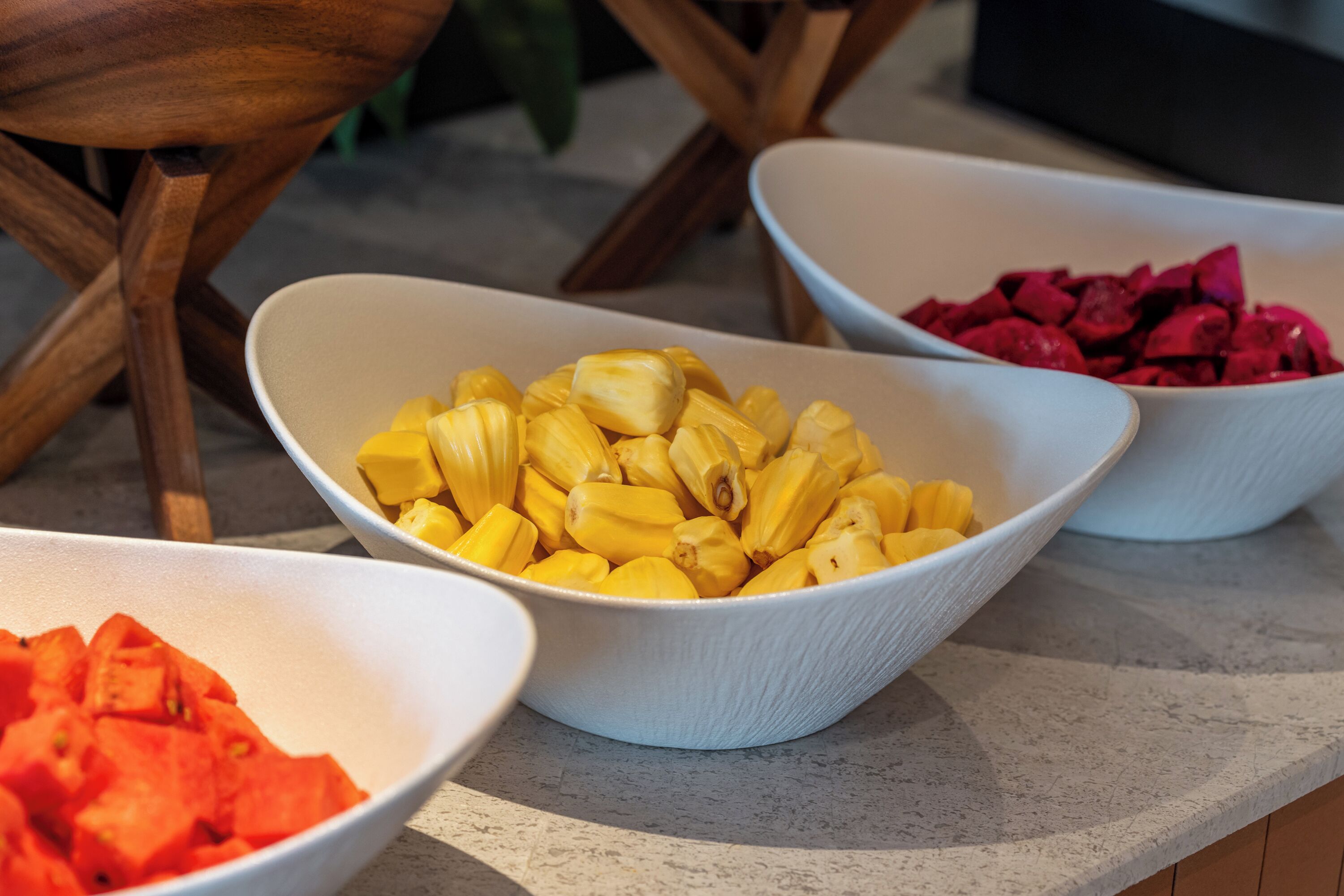 Three bowls of fruit on a countertop.
