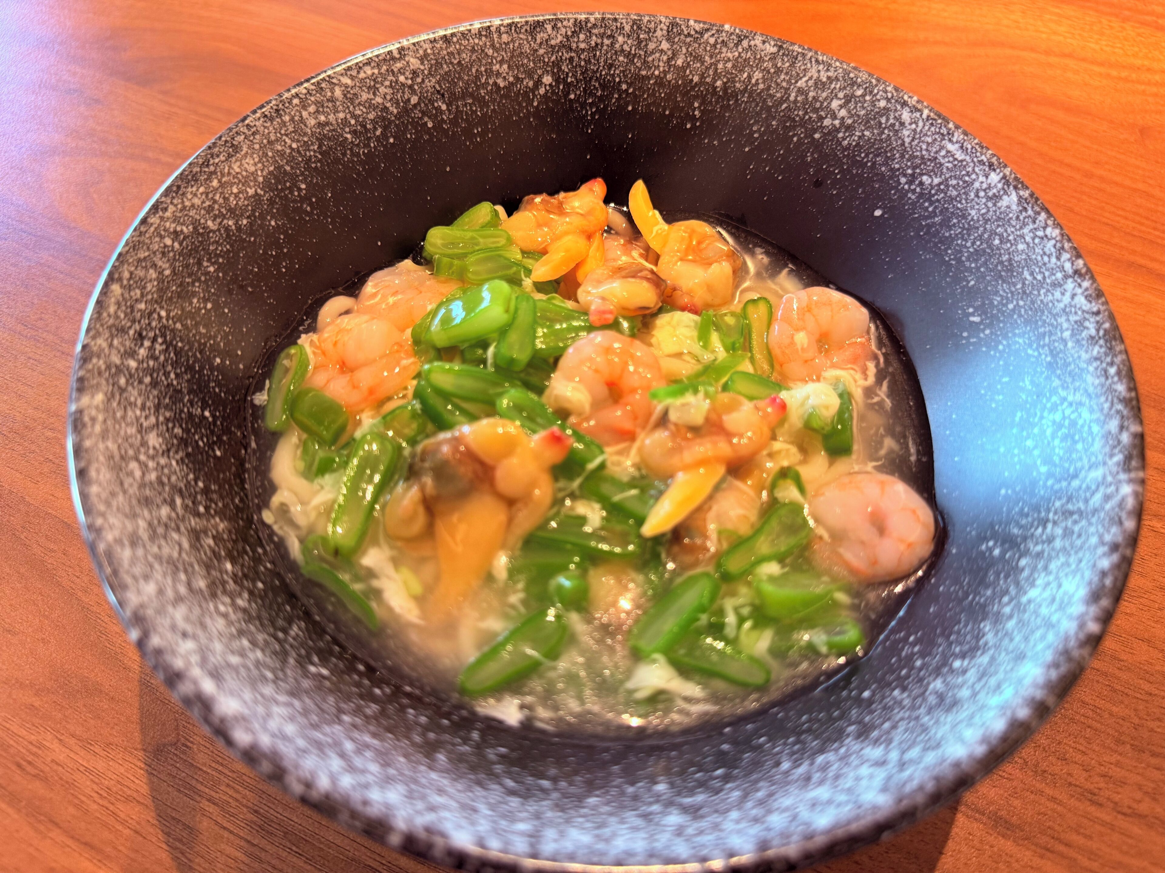 Un plato de comida con camarones y verduras.