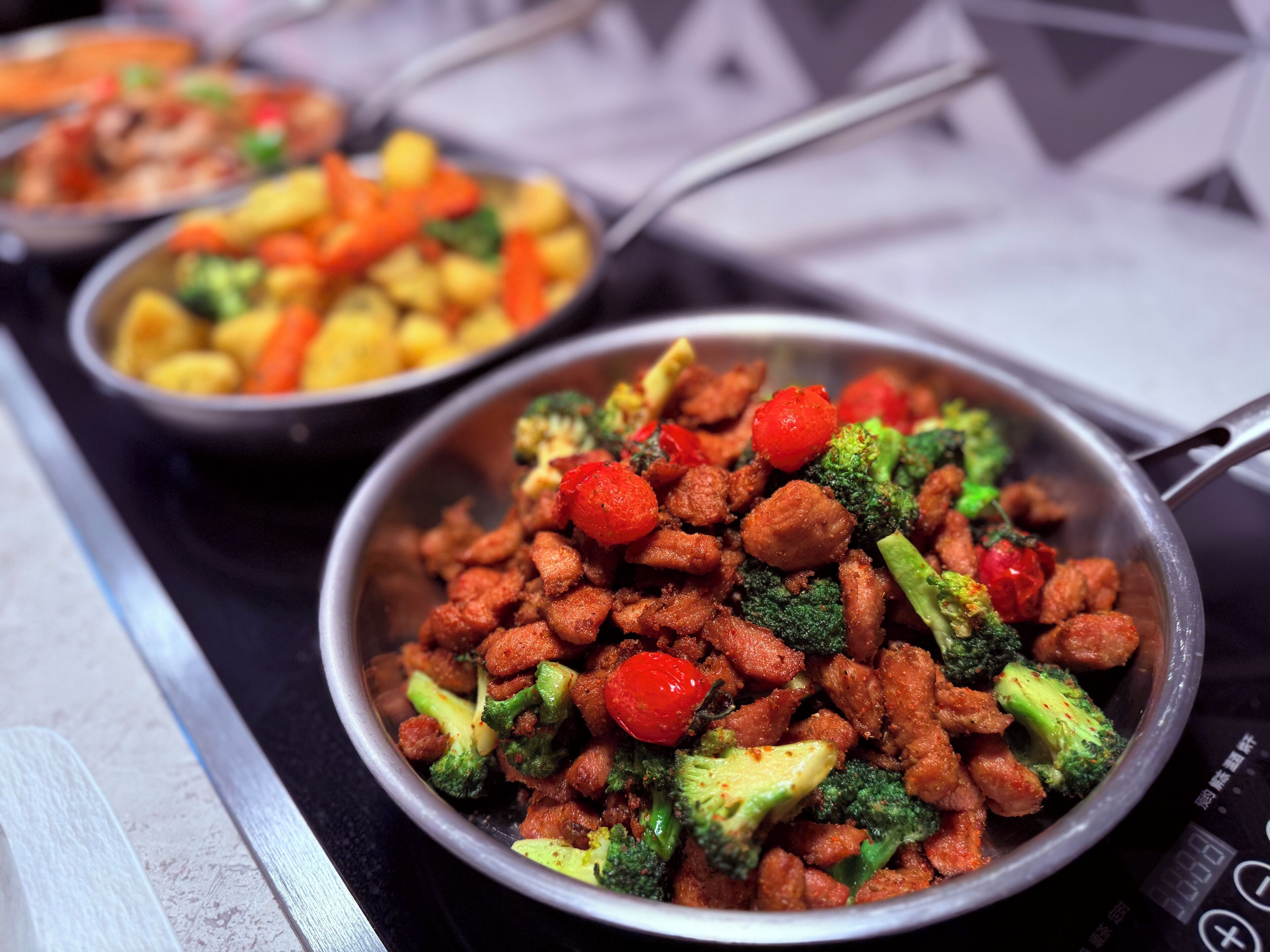 A buffet with various dishes including stir-fried meat and vegetables.