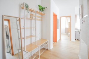 A modern interior with a white shelving unit, a potted plant, and a doorway leading to another room. - nJoy! Superior Apartment Bonlanden | Airport/ EXPO (Filderstadt)