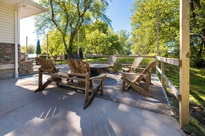 An outdoor patio with wooden furniture, a grill, and a view of trees. - Private Beach Access + Hot Tub / Near Wineries / Lake Erie Retreat / Sleeps 12 (North East)
