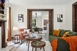 A living room with a sofa, armchair, coffee table, and a fireplace. - 6BR · Game Room · Free Parking · Near Stadiums (Pittsburgh)