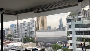 Blick aus einem Fenster auf eine Stadtlandschaft, mit Hochhäusern und einem Parkplatz.