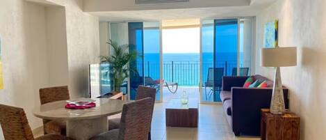 A spacious living area with a balcony, a dining table, and a sofa.