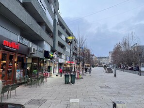Eine Straße mit Geschäften, darunter ein Kaffeehaus und ein Bekleidungsgeschäft.
