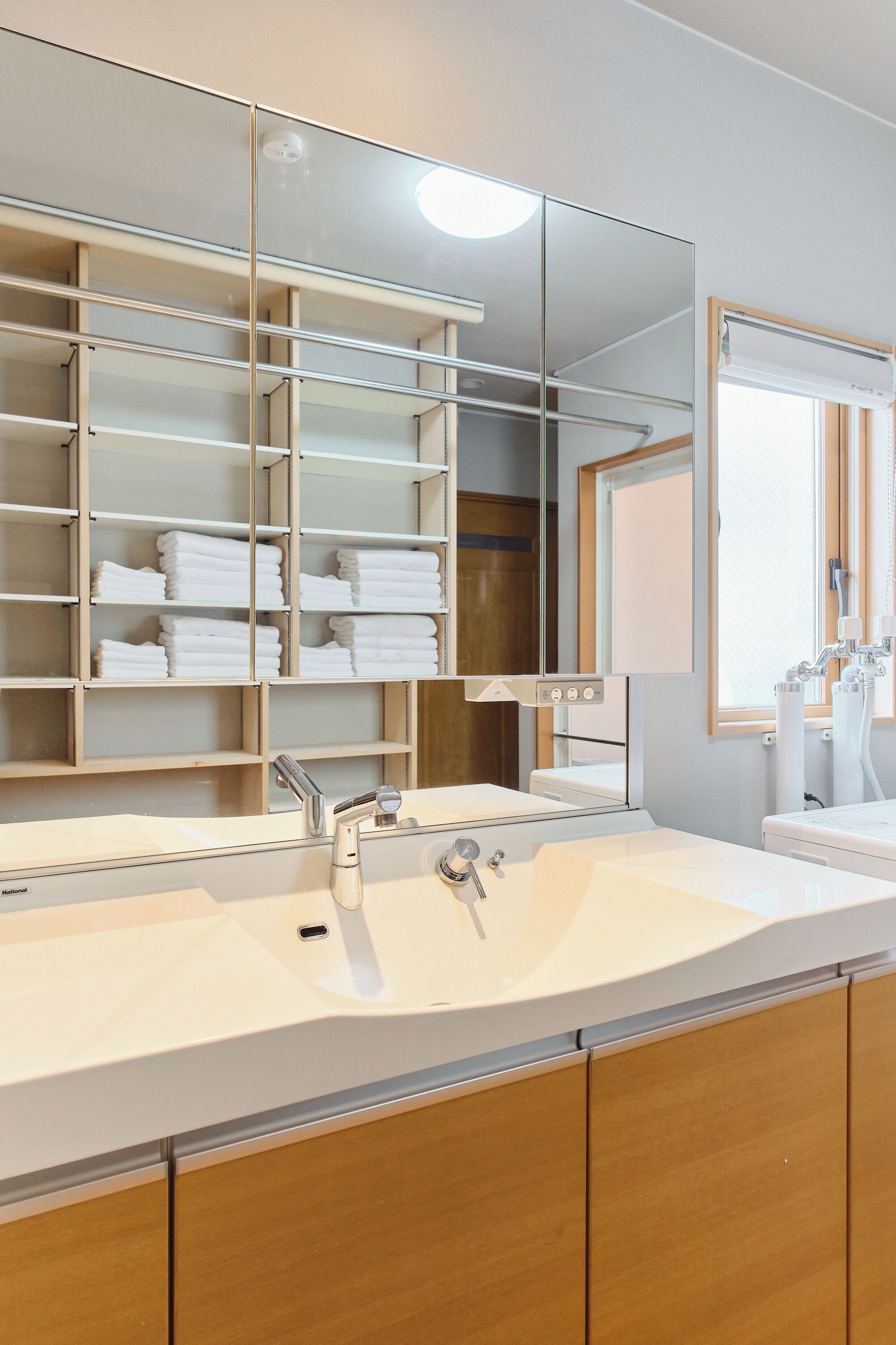 A modern bathroom with a large mirror, dual sinks, and a towel rack.