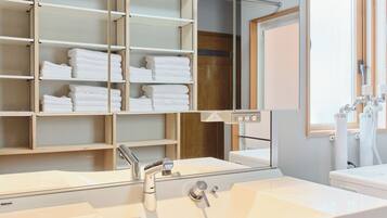 A modern bathroom with a large mirror, dual sinks, and a towel rack.
