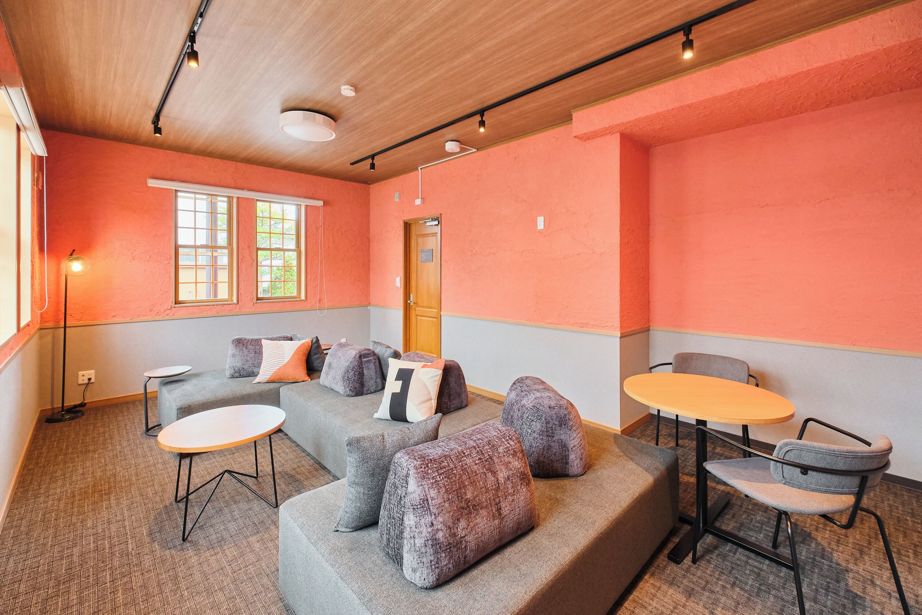 A modern interior with a sectional sofa, ottomans, a small round table, and a chair.