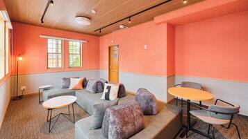 A modern interior with a sectional sofa, ottomans, a small round table, and a chair.