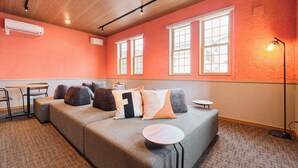 Una habitación con un sofá modular, una mesa redonda y una lámpara de pie.