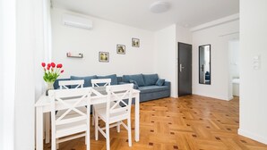 Una sala moderna con una mesa de comedor, sillas, un sofá y una mesa de centro.