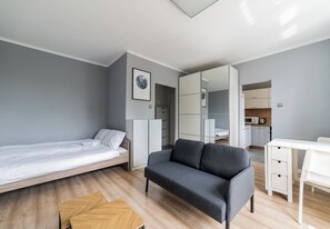 A modern room with a bed, sofa, desk, and wardrobe. - Grunwald Comfort Apartment (Poznań)