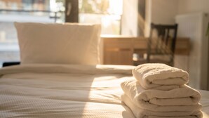 A bed with a stack of folded towels and a pillow. - Tauron Arena Harmony Apartment (Kraków)