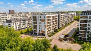 A modern apartment complex with multiple floors, balconies, and a parking area. - Tauron Arena Harmony Apartment (Kraków)