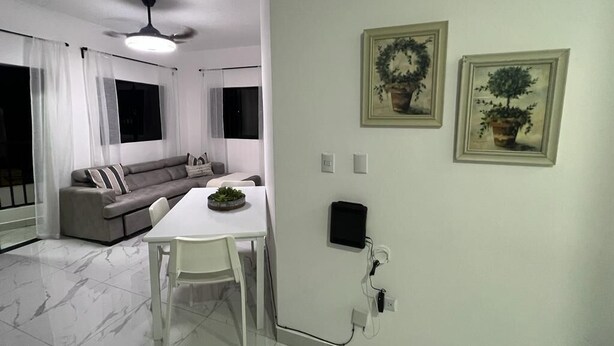 A modern living room with a sofa, a dining table, and a ceiling fan. - Beautiful apartment in the city center (Santo Domingo)