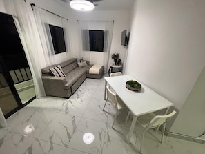 A modern living room with a sofa, a dining table, and a small side table. - Beautiful apartment in the city center (Santo Domingo)