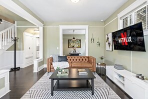 Ein Wohnzimmer mit Sofa, Couchtisch und einem Fernseher, der das Netflix-Logo zeigt.