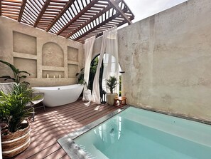 Ein Wellnessbereich mit Whirlpool, kleinem Pool, Holzterrasse, Topfpflanzen und einer Pergola.