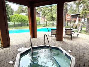 A covered outdoor swimming pool with a hot tub, surrounded by lounge chairs and a wooden deck. - Spacious + Pet Friendly + Walk to Village - 2/2 (Mammoth Lakes)