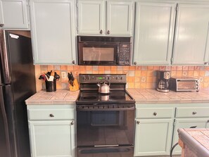 A kitchen with a stainless steel refrigerator, a black microwave, a stove, and a toaster. - Spacious + Pet Friendly + Walk to Village - 2/2 (Mammoth Lakes)